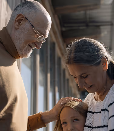 Three generations of a family together grandparents tenderly connecting with a young grandchild