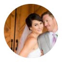 Smiling man with dark hair and beard in a dimly lit setting.