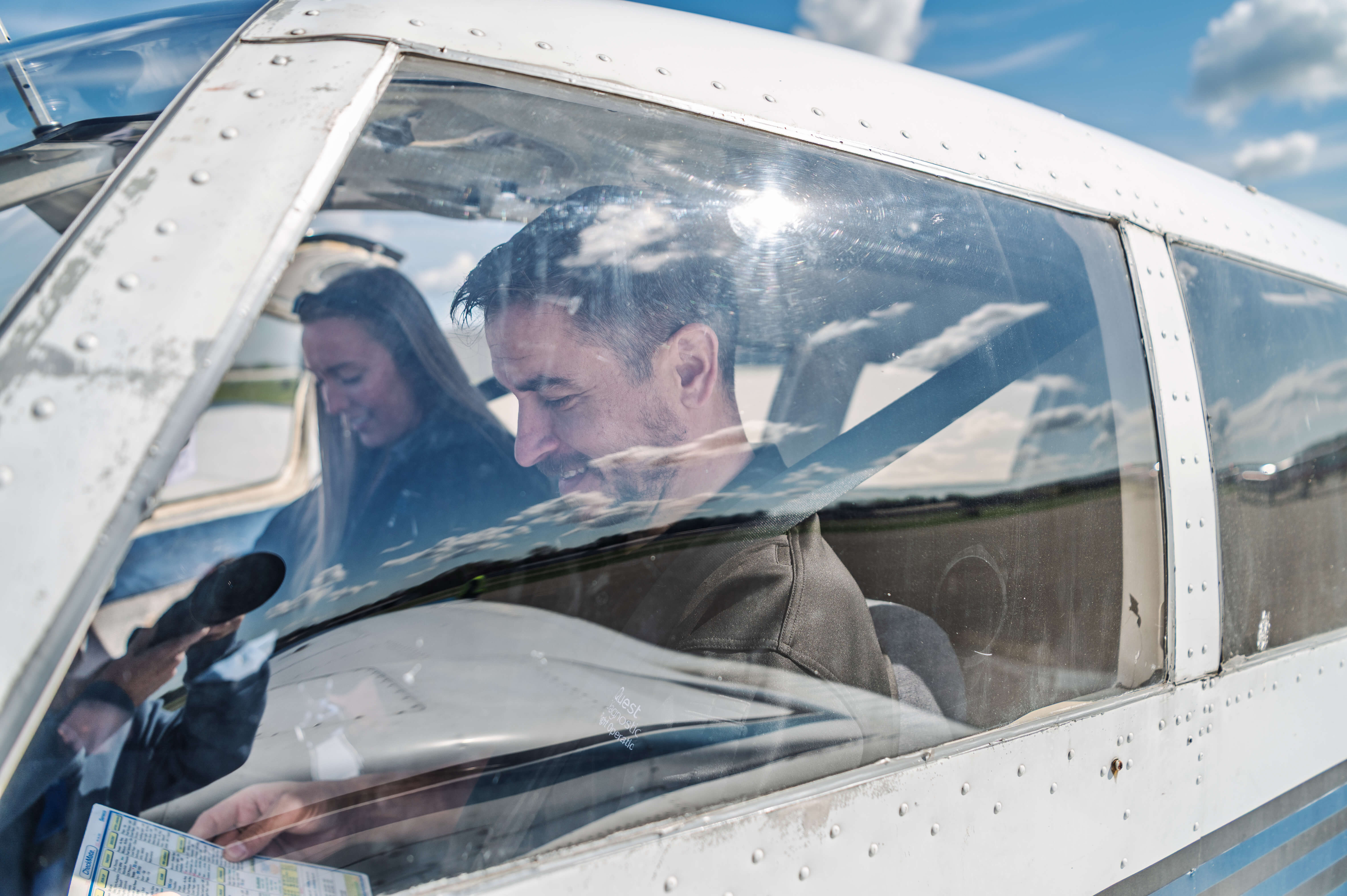A High Flight Academy instructor with a student the cockpit reviewing a flight checklist.