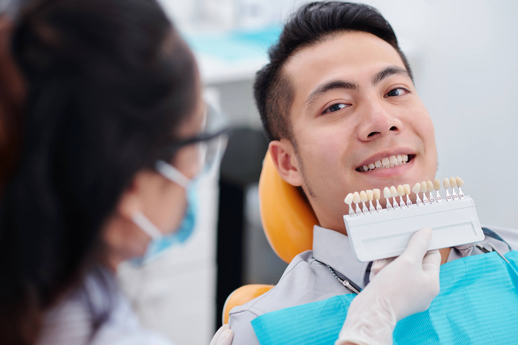 man choosing shade for his teeth whitening