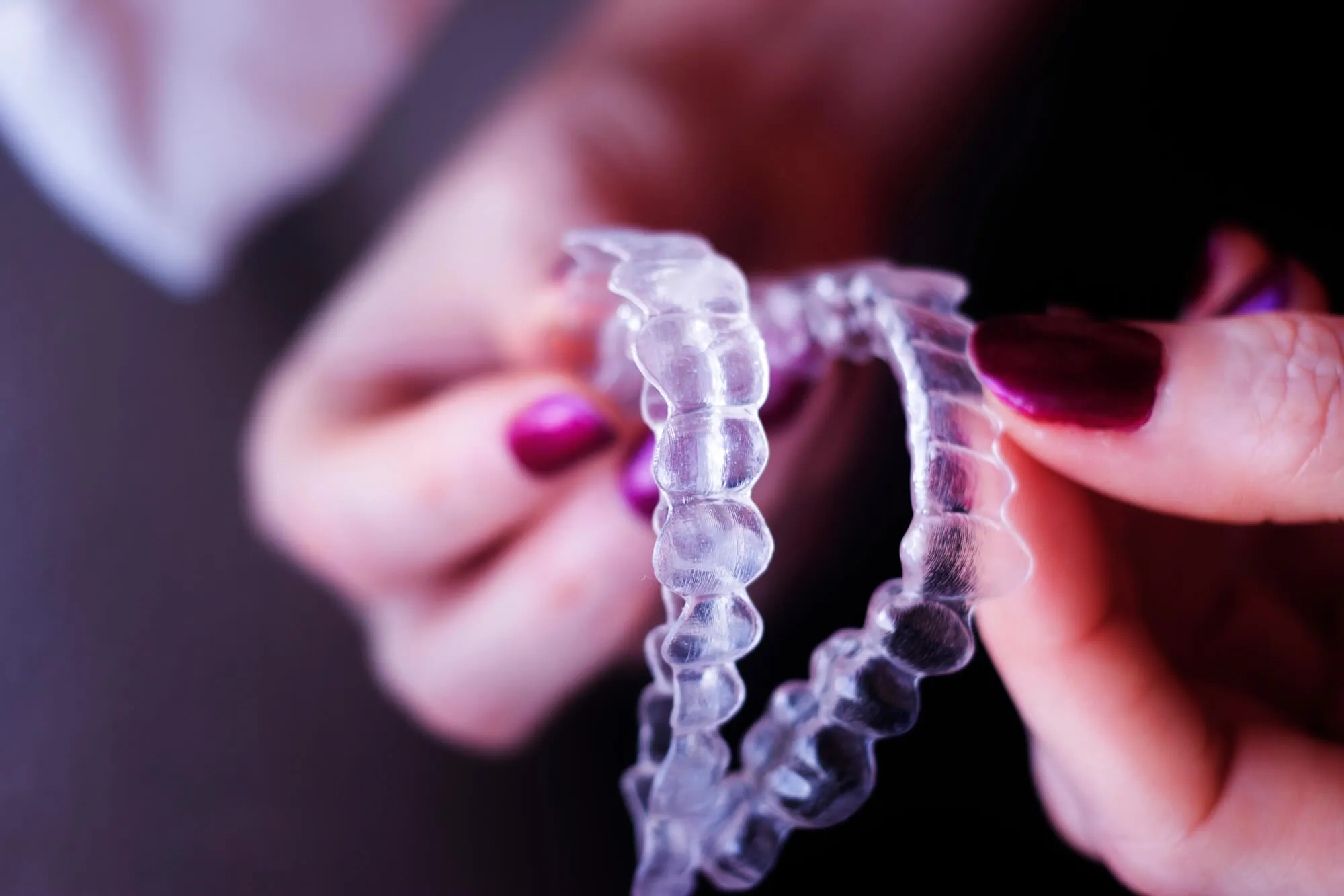 woman holding upper and lower clear aligners