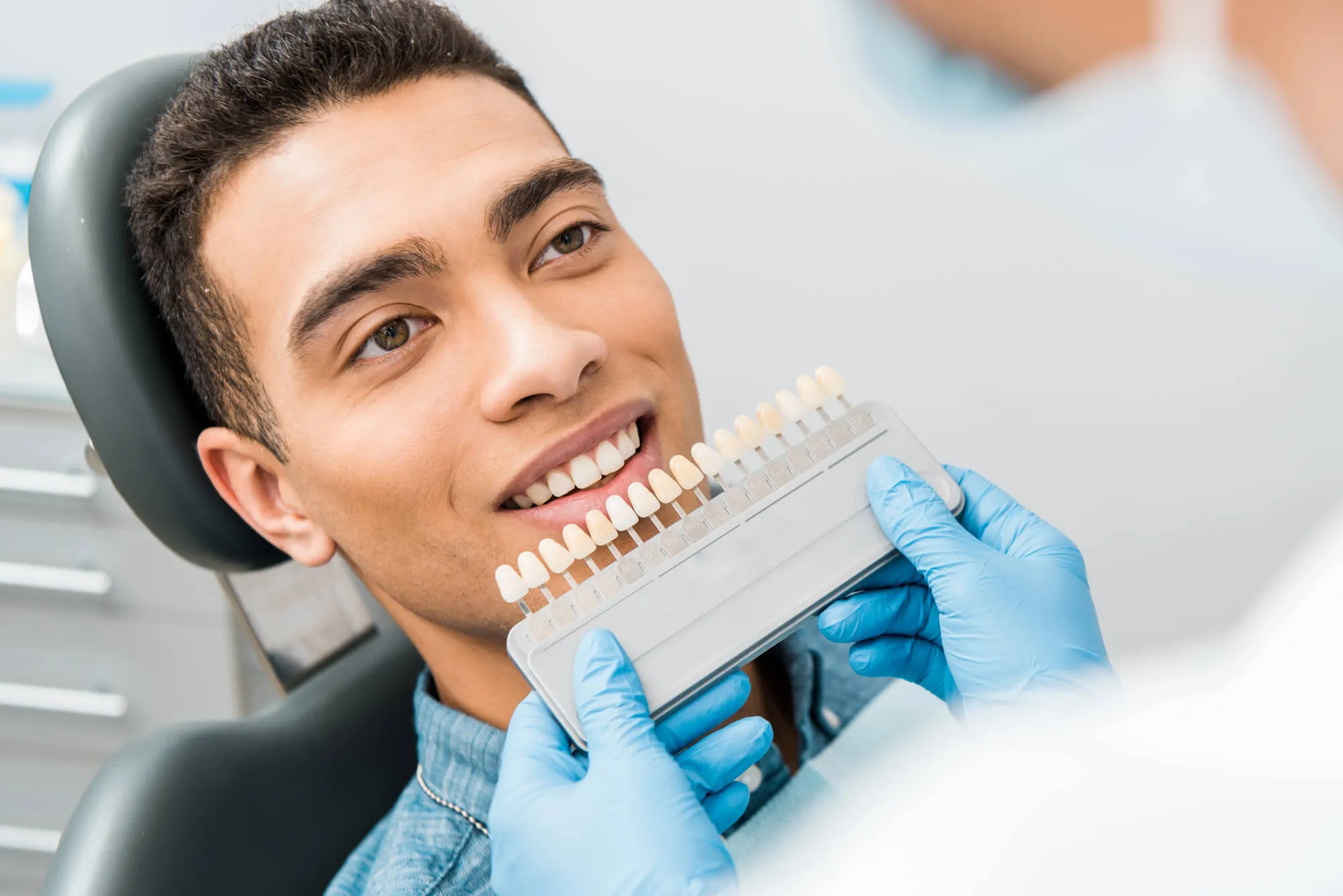 man choosing shade for his teeth whitening