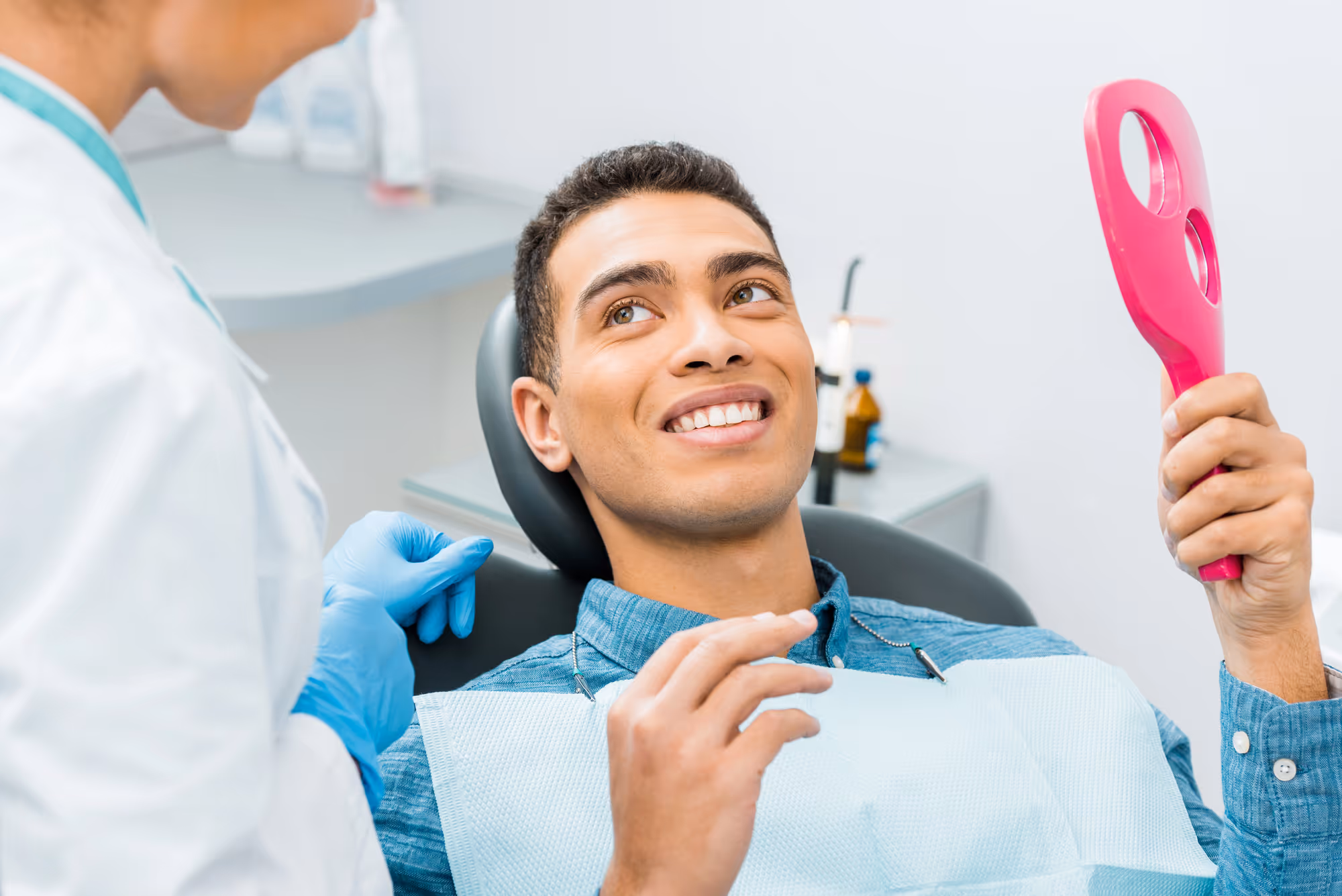 man smiling after looking at his smile in the mirror