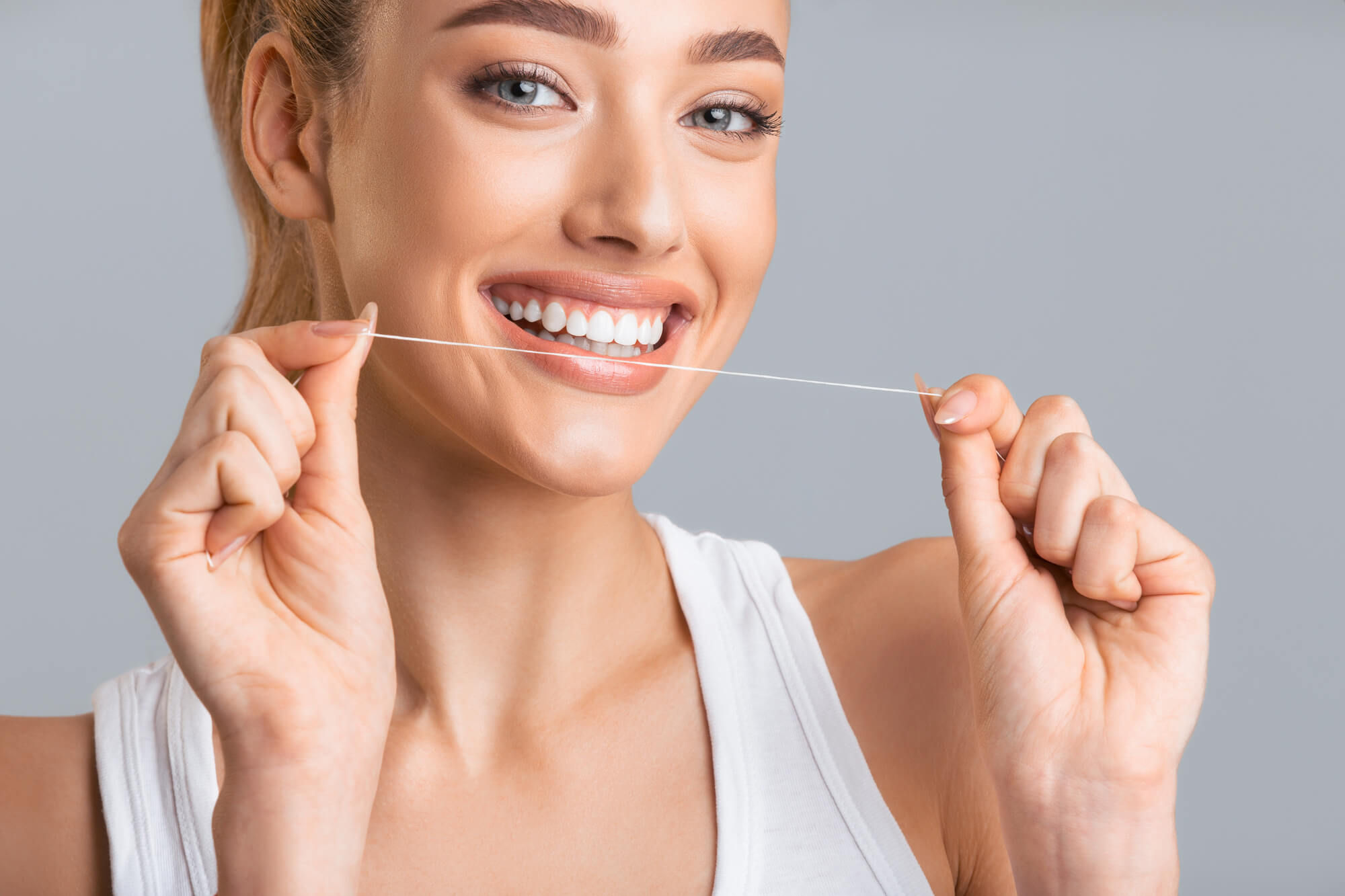 woman smiling and flossing