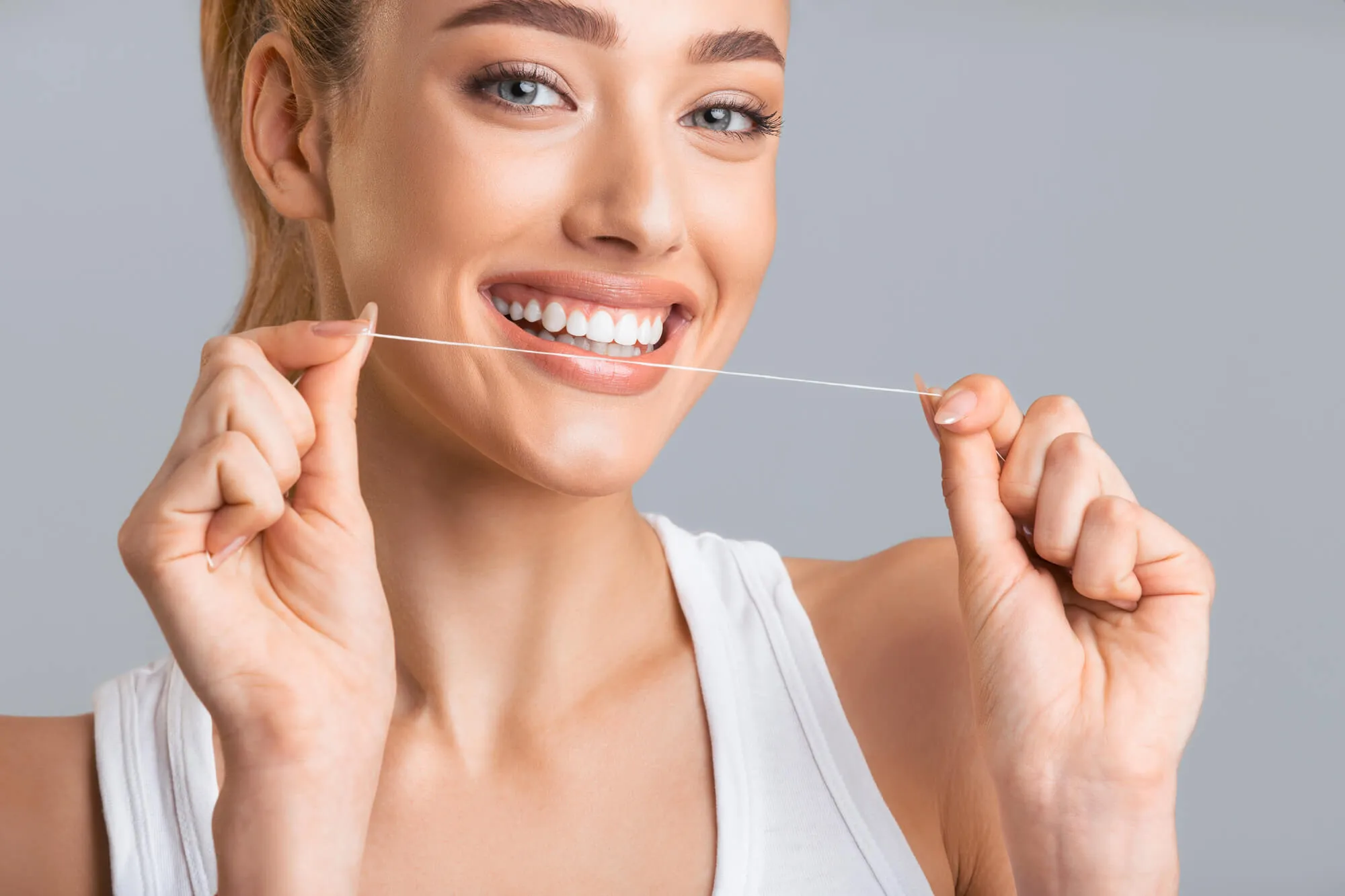woman smiling and flossing
