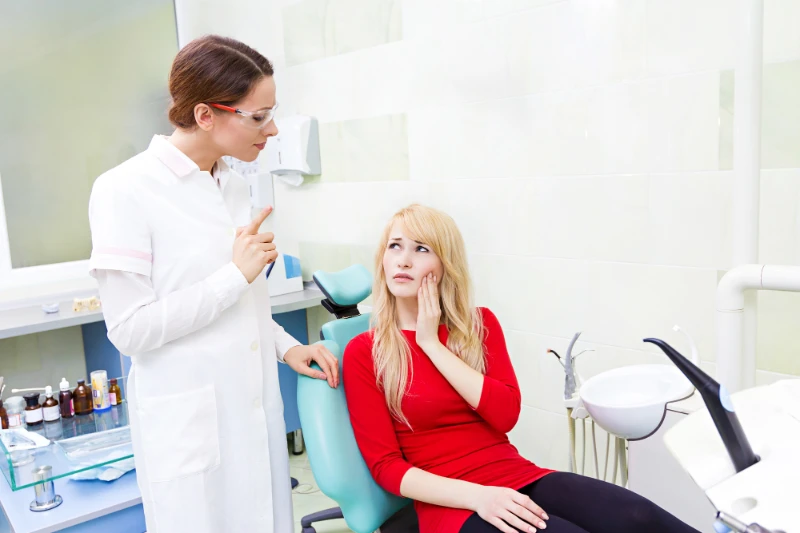 woman with dental pain talking to her dentist