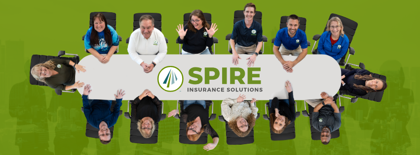 The Spire Team sits around a conference table with the logo in the middle of the table