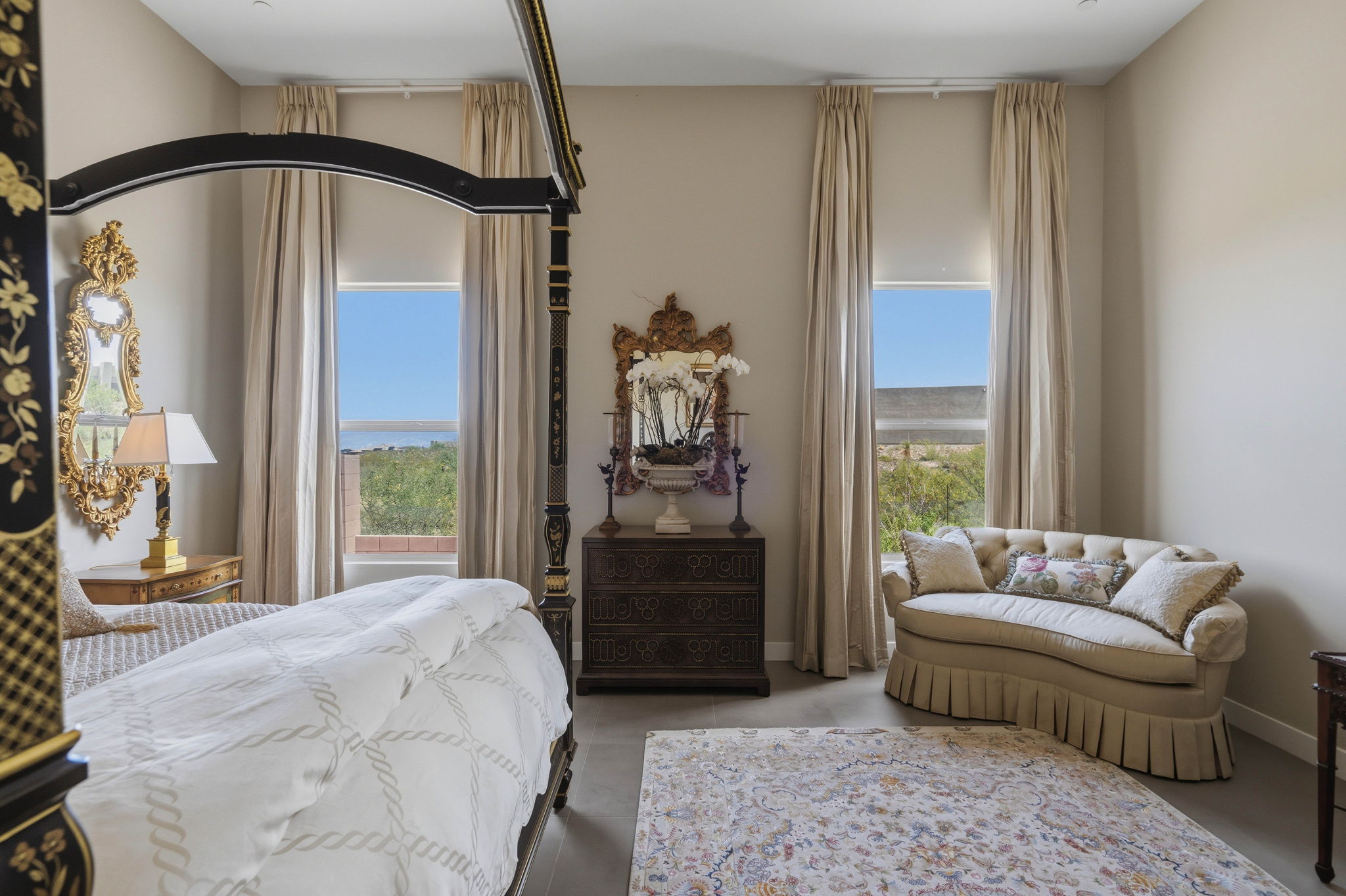 Elegant bedroom with a canopy bed, sitting area, and desert views.