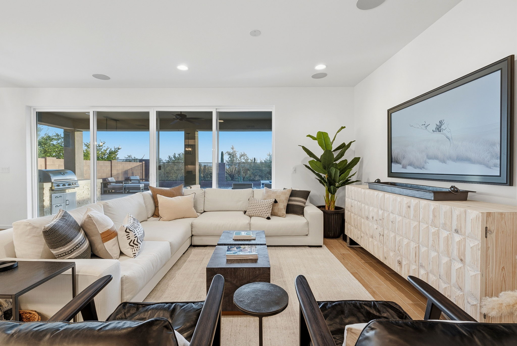 Bright BFP living room with white sectional seating and large patio doors