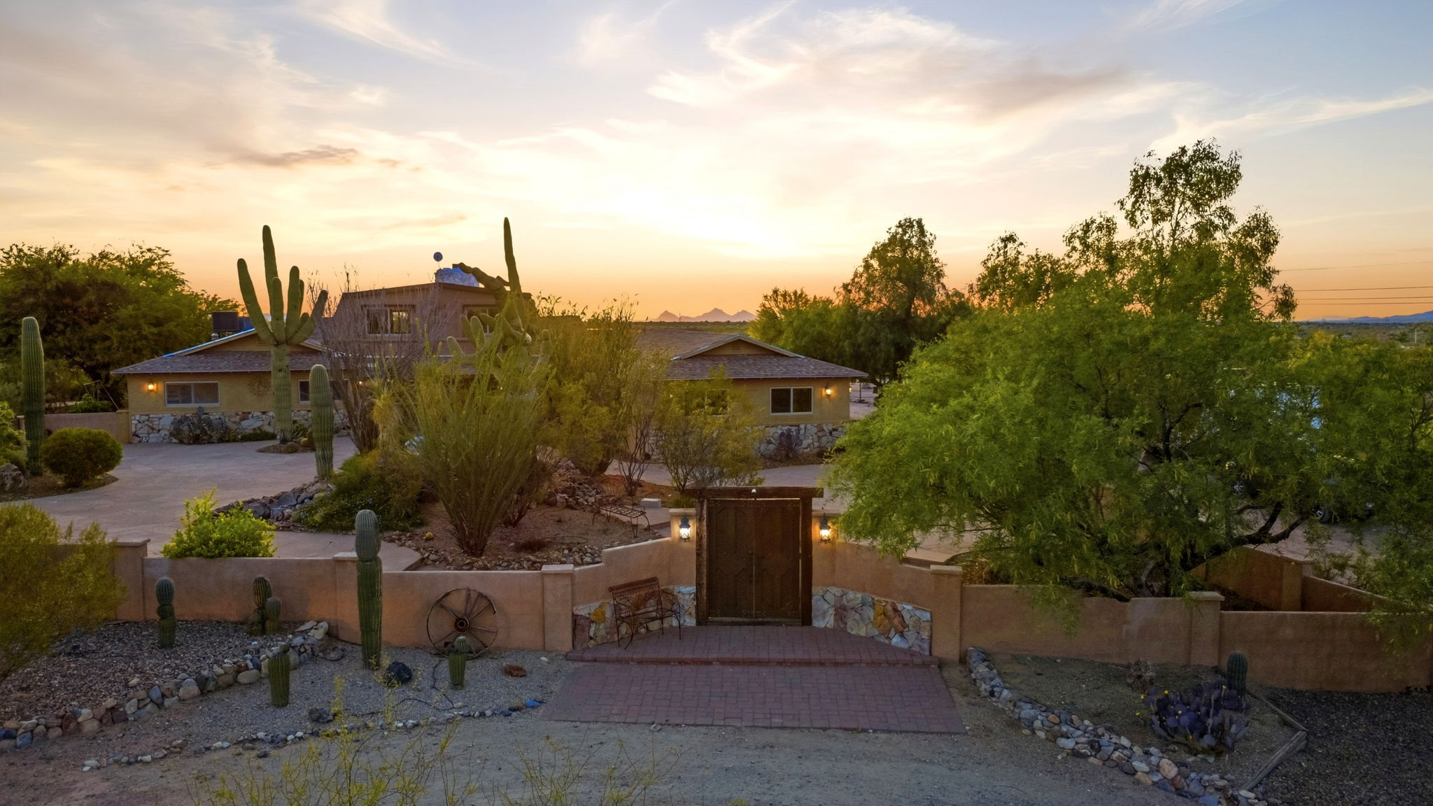 Elevated view of a desert home surrounded by saguaros at sunset