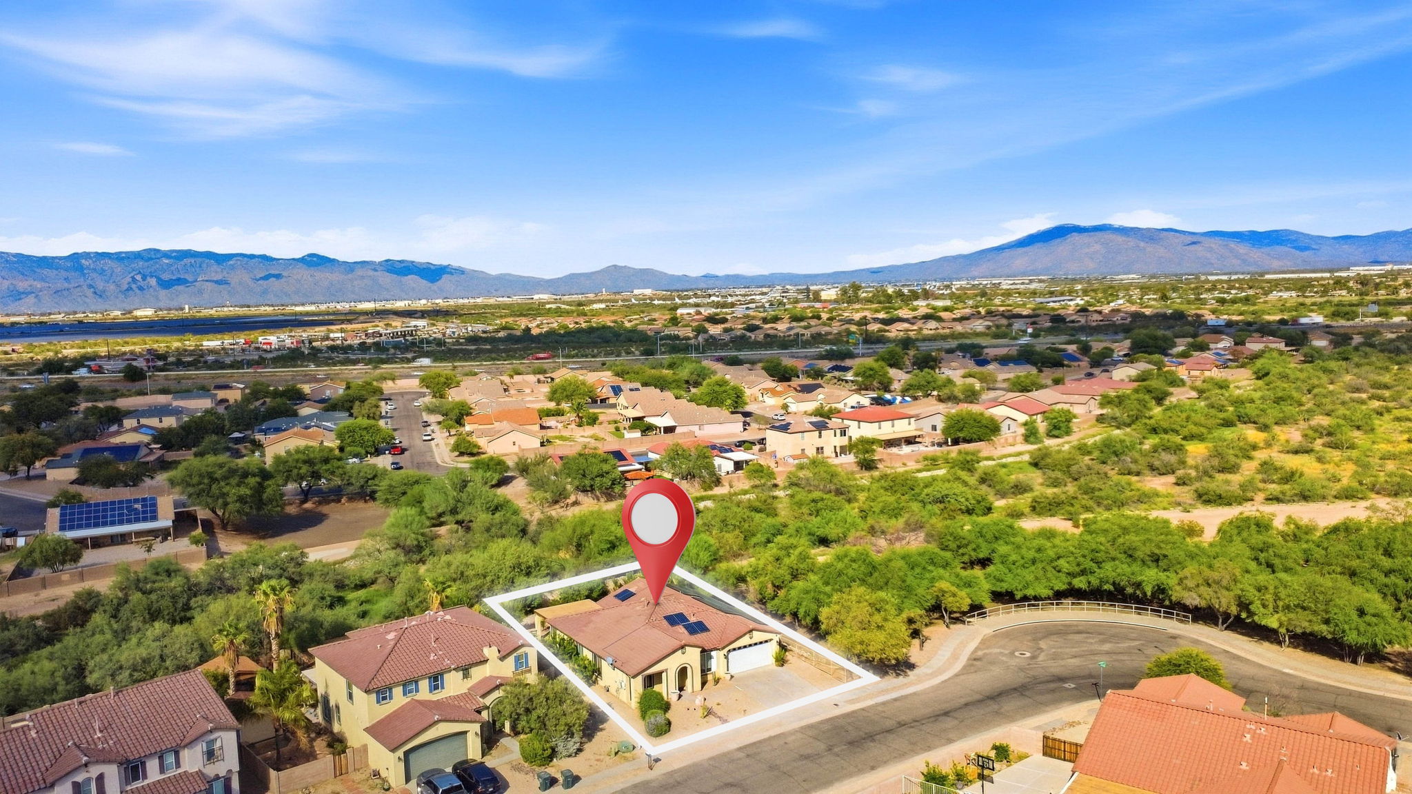 Aerial view of a corner home with lot outline and property marker
