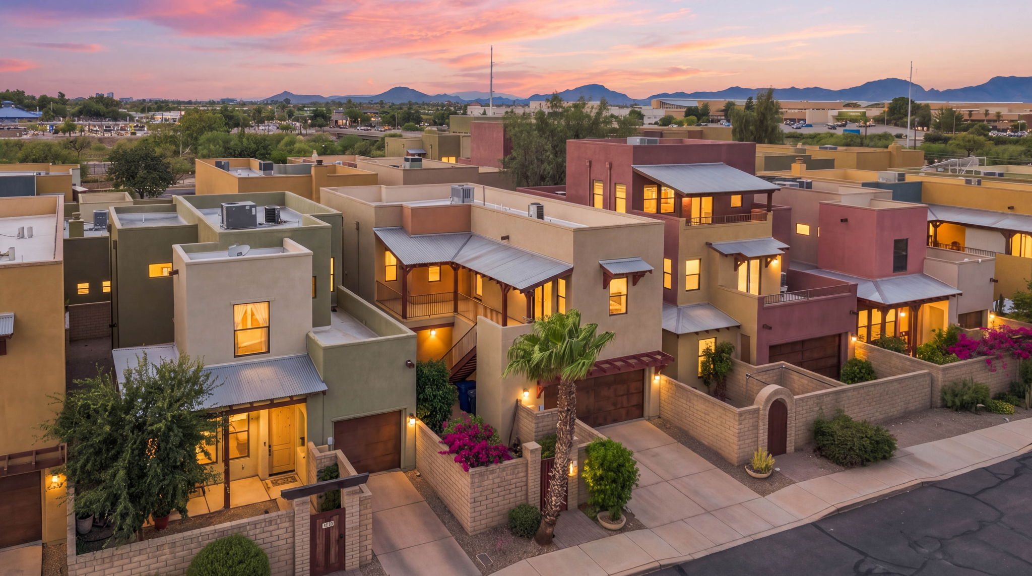 Elevated dusk view of three-story condos with glowing windows