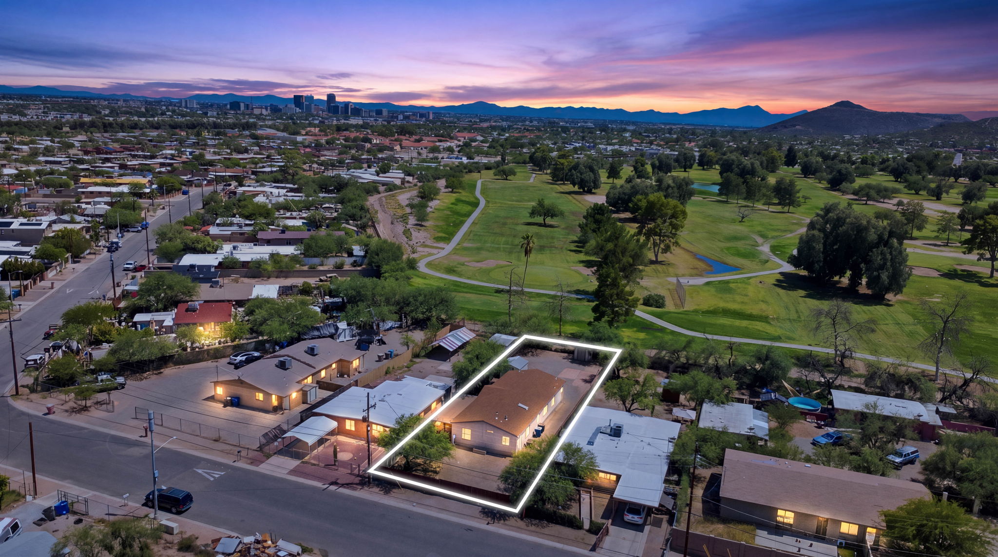 Dusk aerial of an outlined home beside a green park