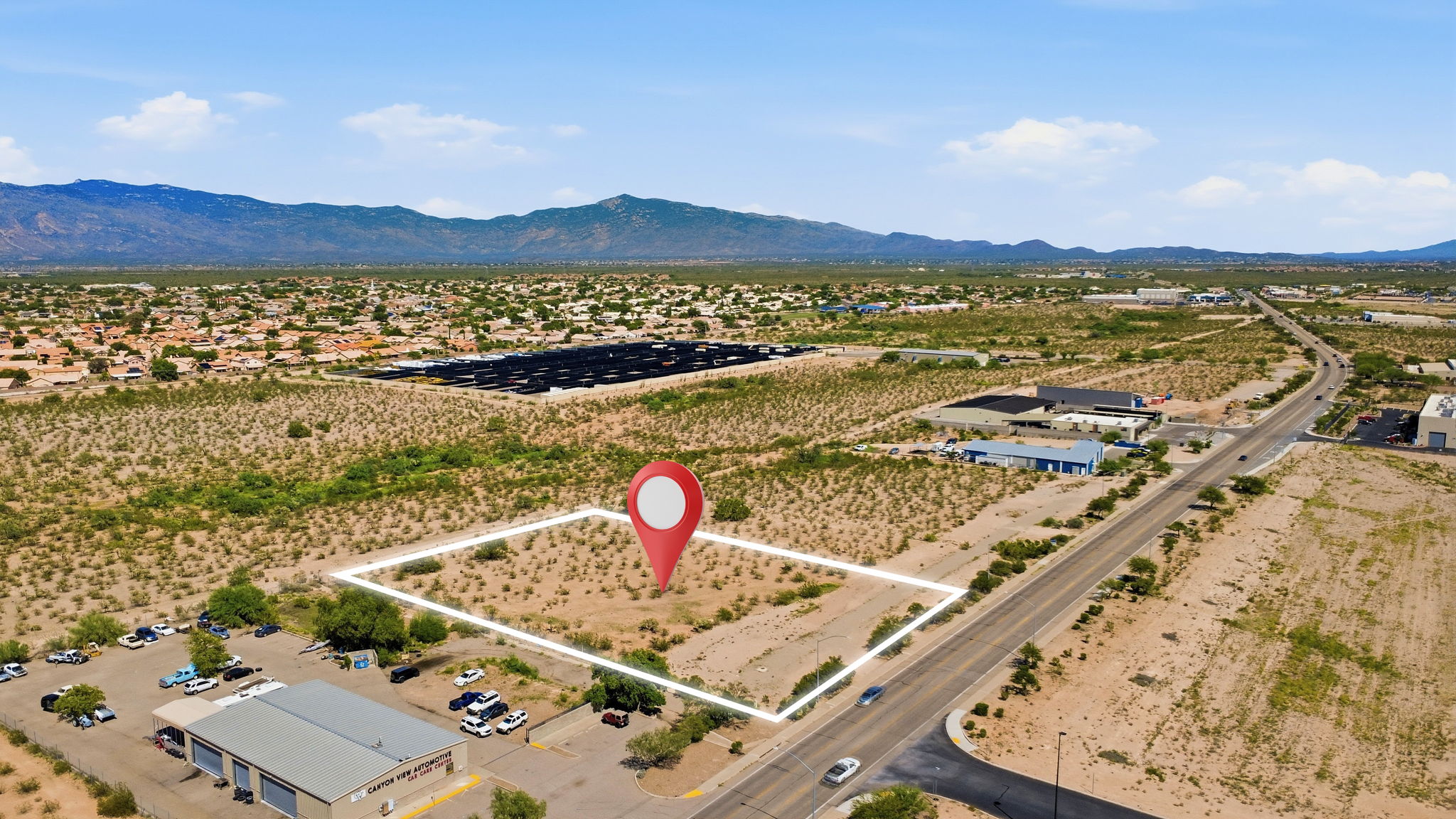 Large open lot outlined with a property marker and mountain backdrop