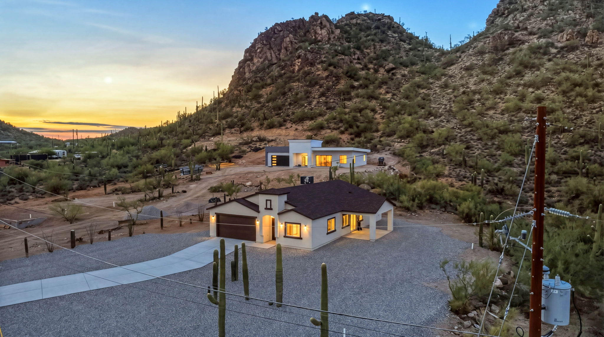 New homes at the foot of a rocky desert hillside at dusk