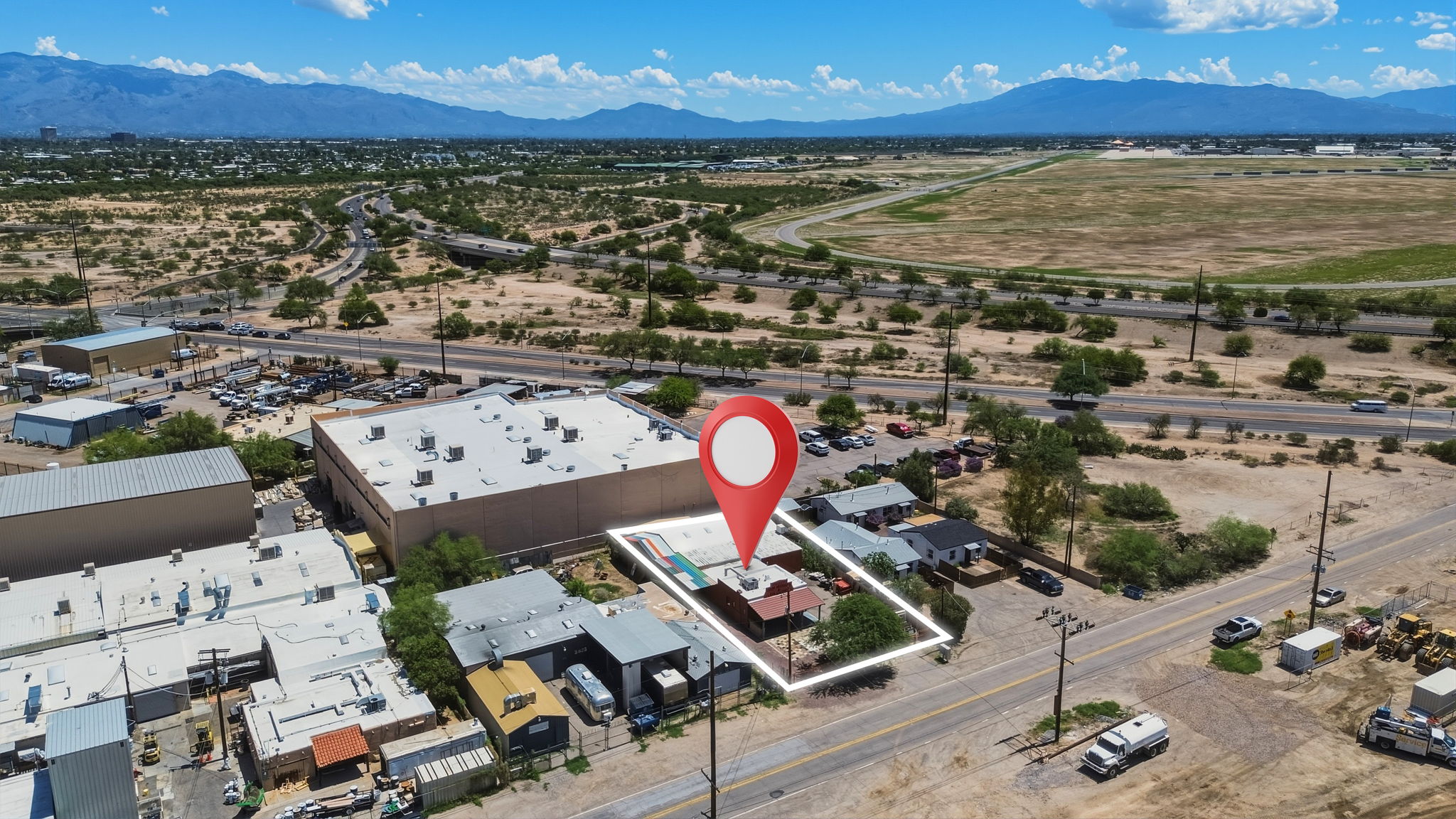 Commercial property outlined and marked from above near an airfield