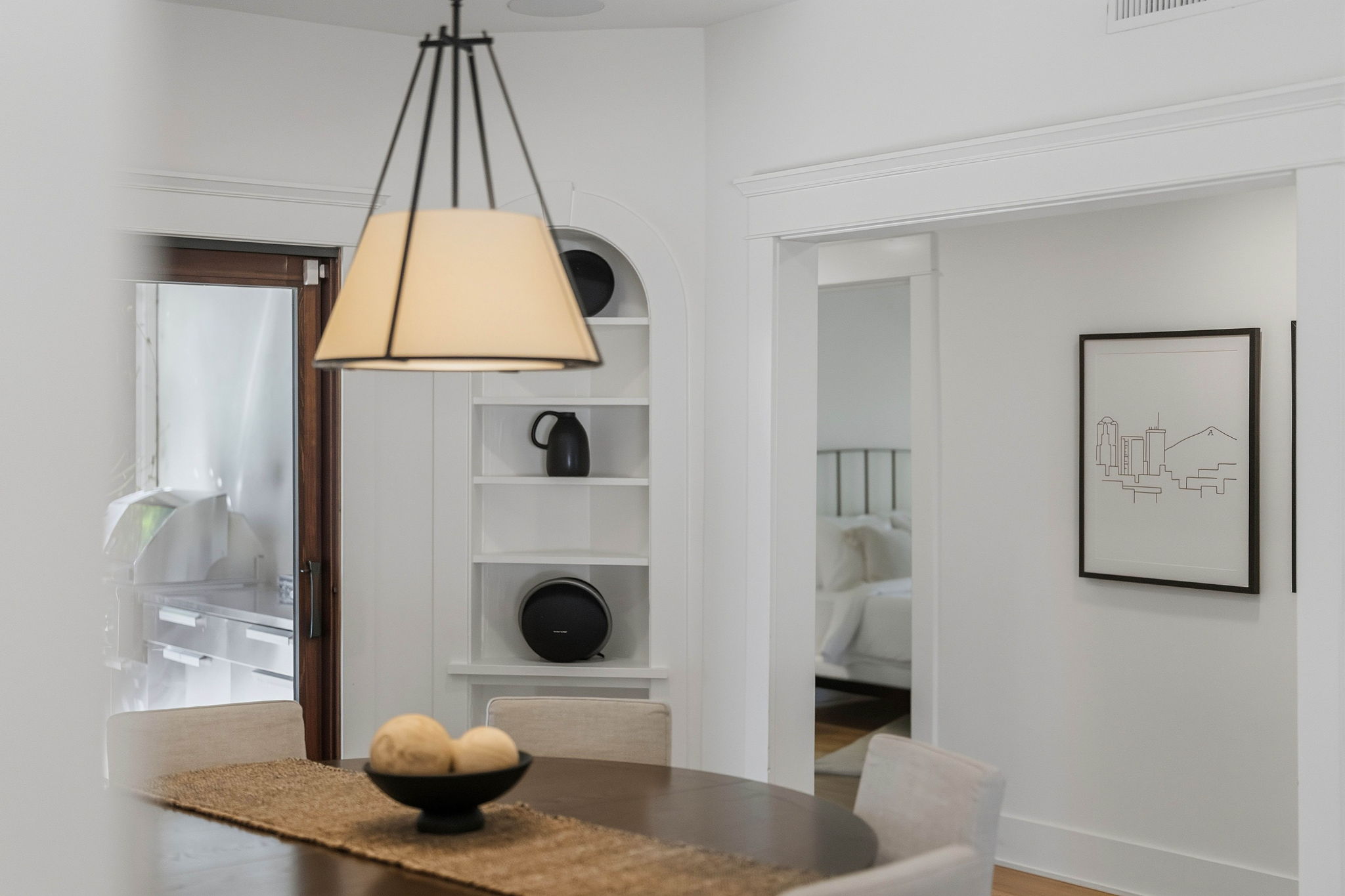 Bright dining area with a pendant light and white built-in shelves