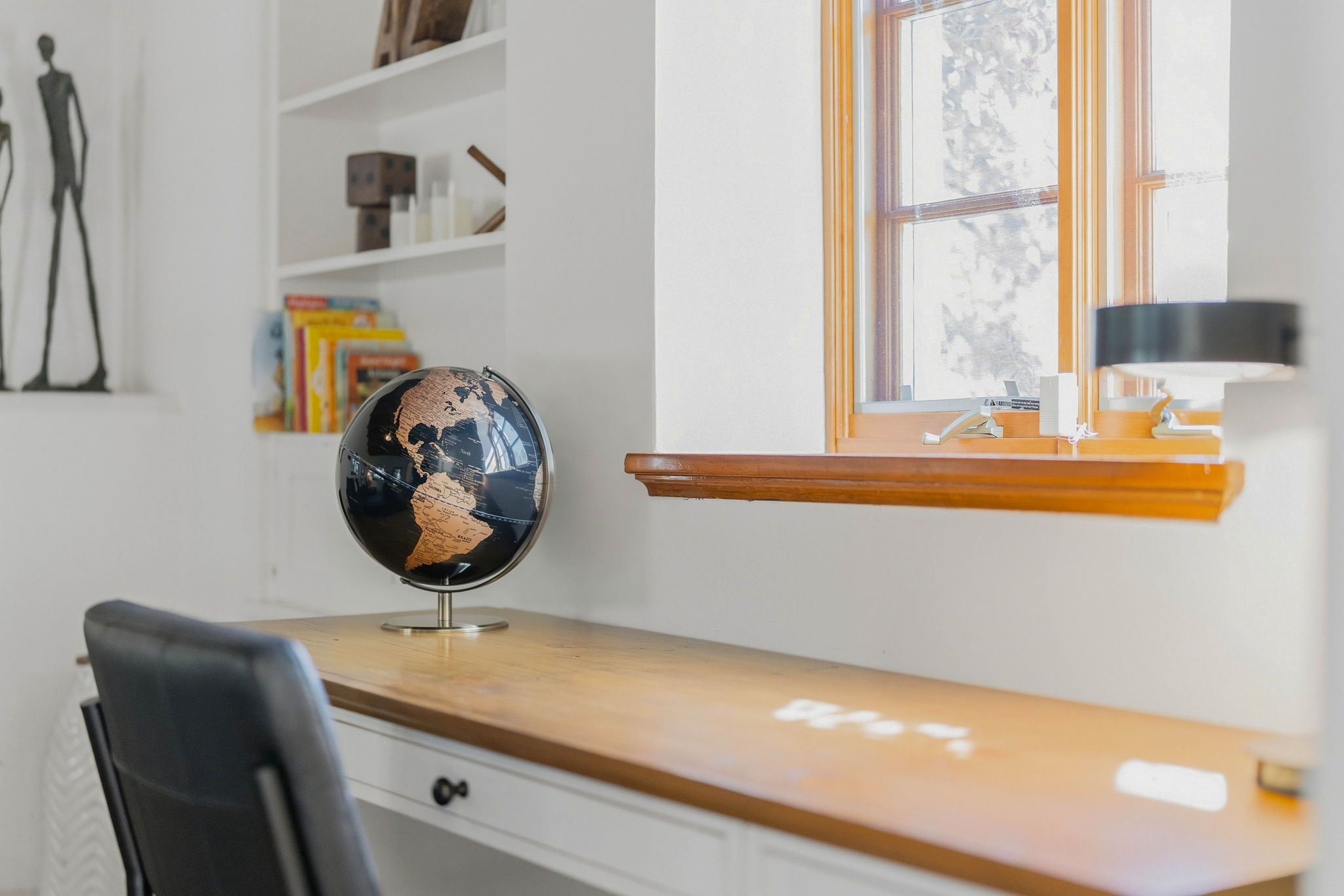 Wooden workspace with a globe beside a sunlit window