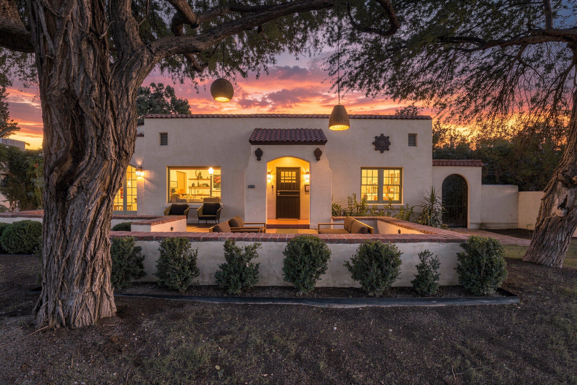 Tucson home exterior with illuminated windows and a digitally enhanced twilight sky