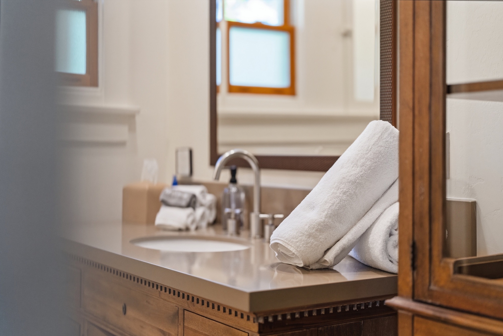 Bathroom vanity with folded towels, a clear countertop and a framed mirror