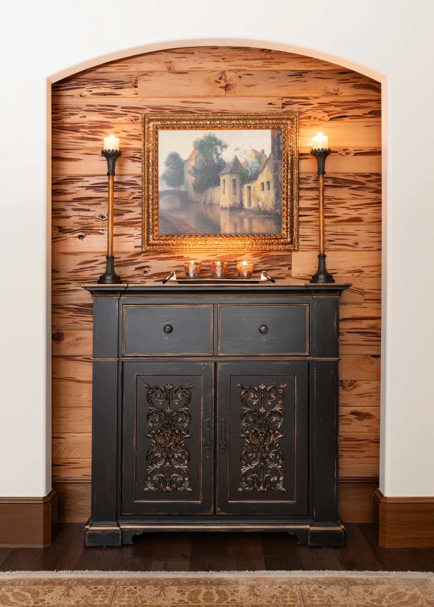 A dark carved cabinet in a wood-lined arch