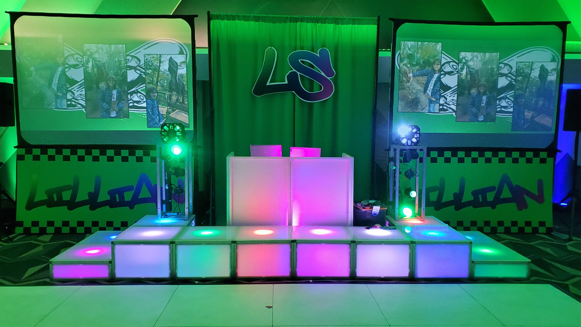 A picture of our DJ Set Up, our Acrylic Light Up Risers, and 2 10' screens and a bunch of green room lighting.