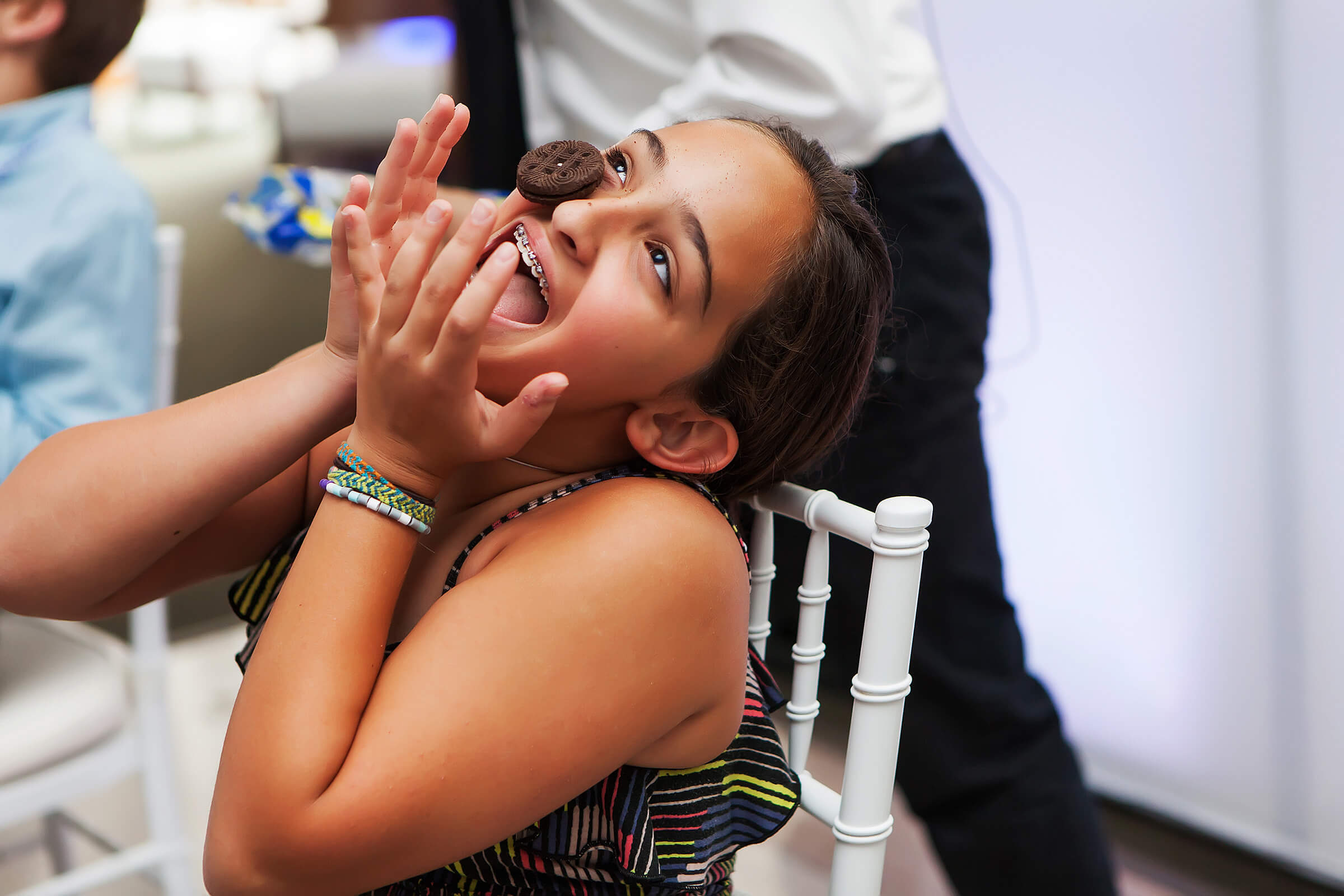 A Picture of a person with a chocolate cookie on their face as they try to make it from their forehead to their mouth, a Party Game called Cookie Face.