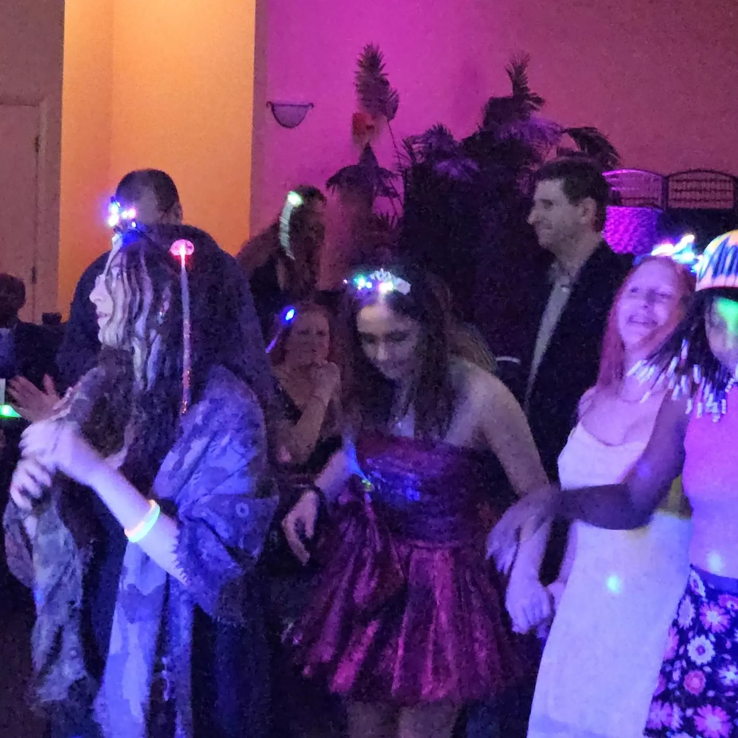 Photo taken at a Bat Mitzvah, where the attendees are wearing light up accessories.