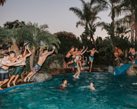 Picture of a bunch of teenage kids jumping into a lifestyle community clubhouse pool.