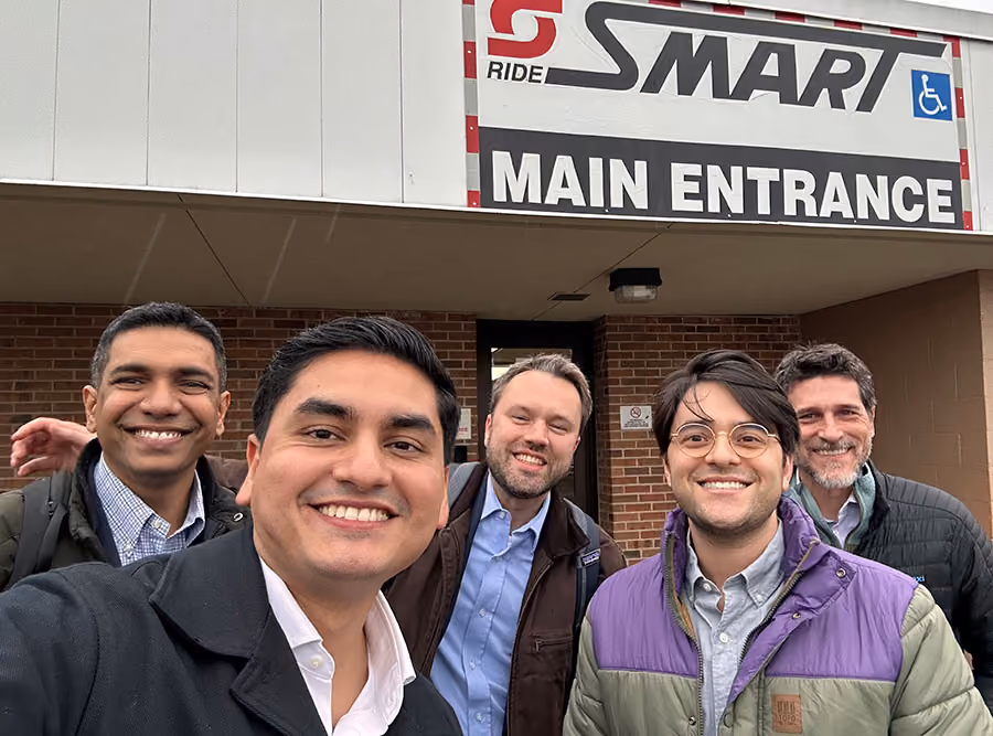 Group selfie of Swiftly employees at the SMART transit main entrance during a site visit.
