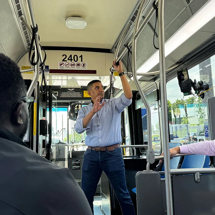 Swiftly employee Ritesh Warade speaking to passengers while standing inside a city bus.