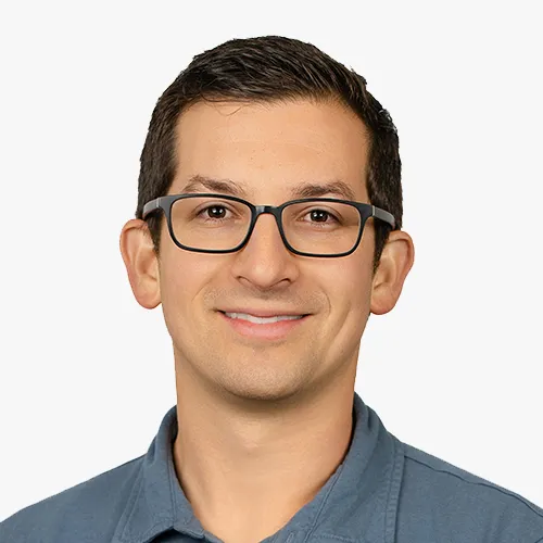Headshot of Jonny Simkin smiling against a plain background.
