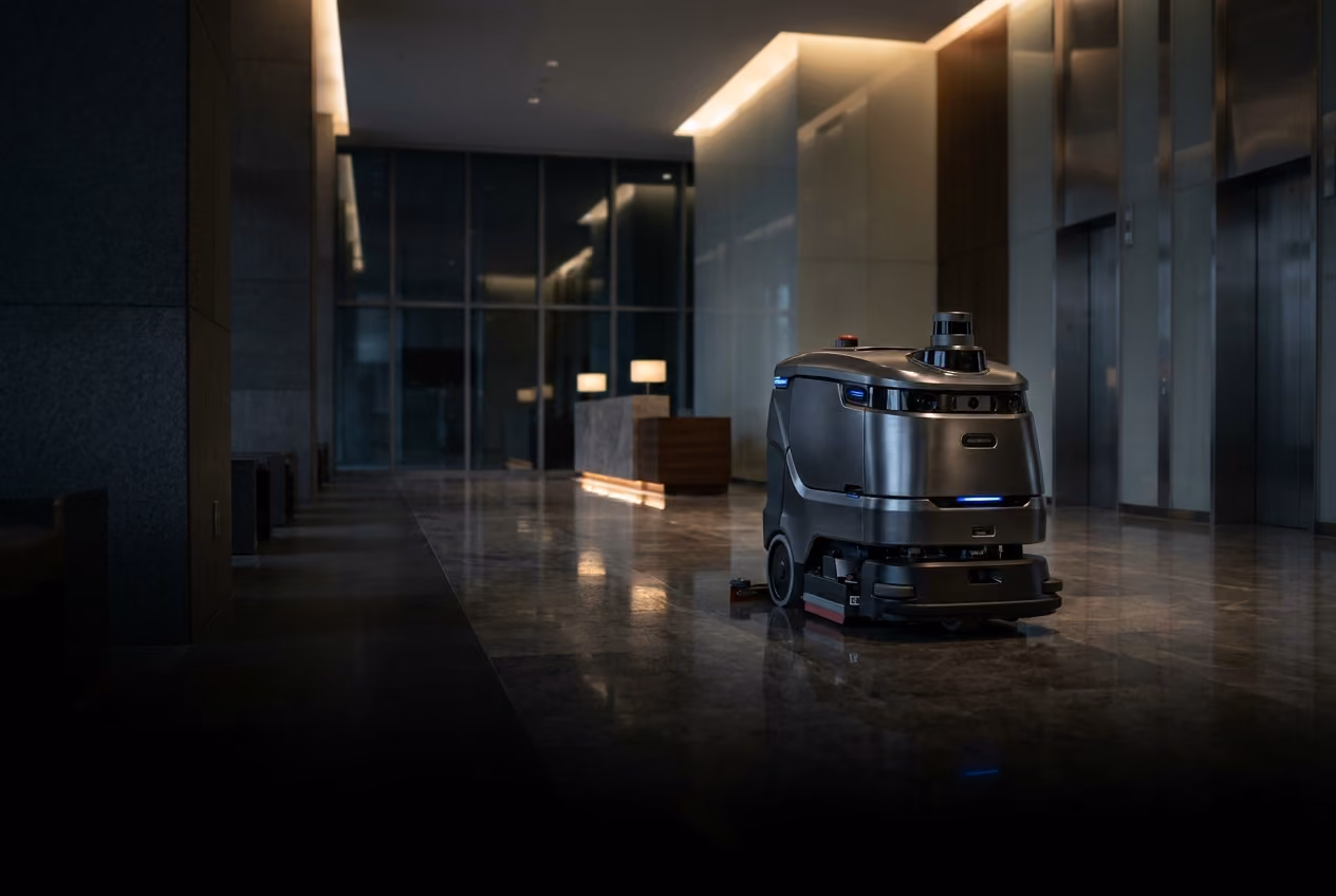 Autonomous cleaning robot operating in a commercial building lobby.