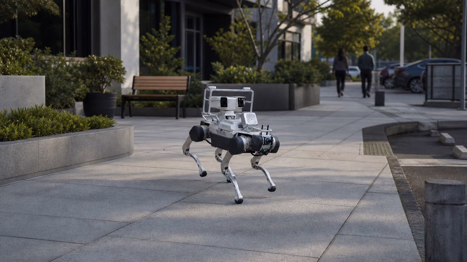 Genericized quadruped patrol robot on a managed commercial-property route with distant people.