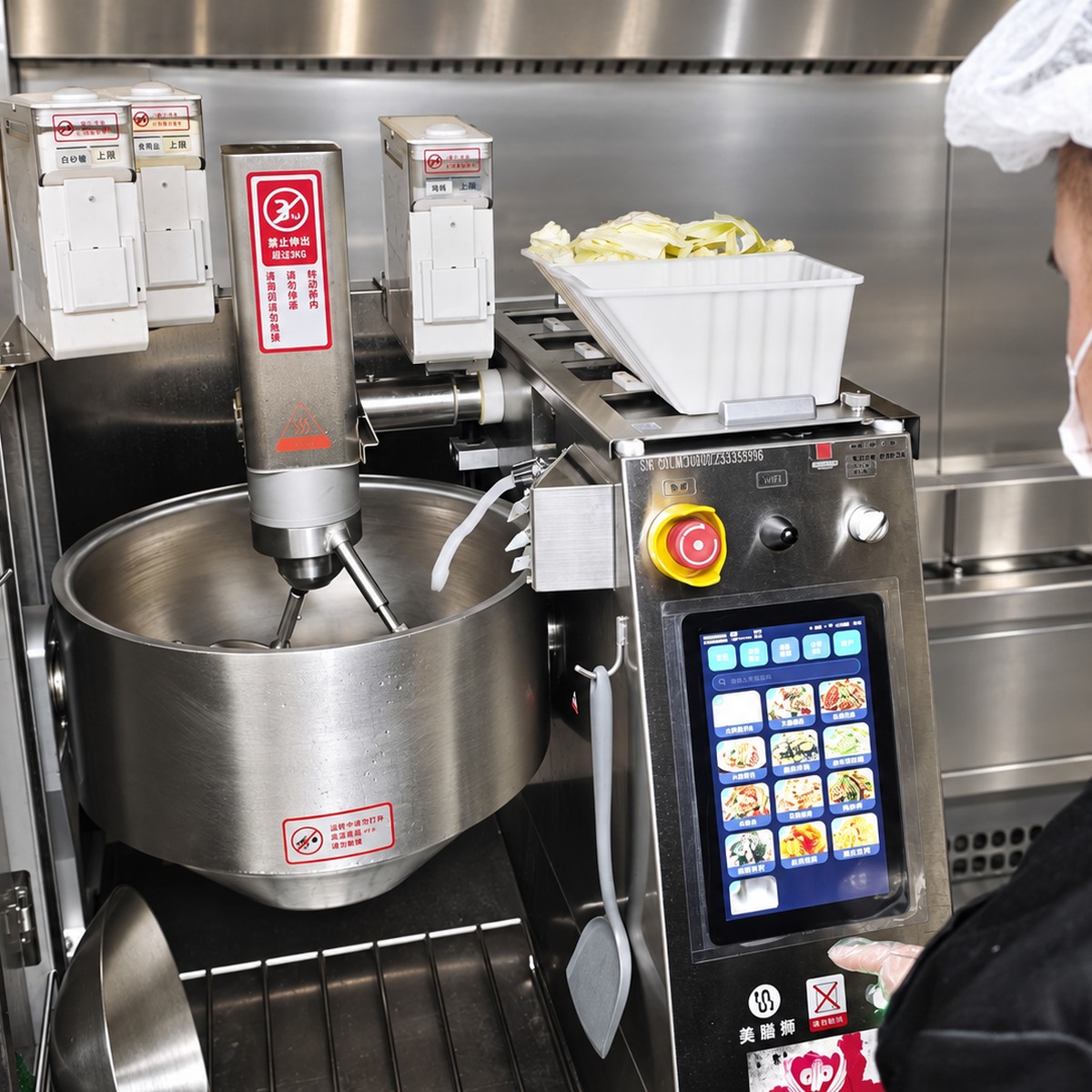 Cooking robot mixing assembly, ingredient tray and control panel showing interfaces to specify before vendor selection.