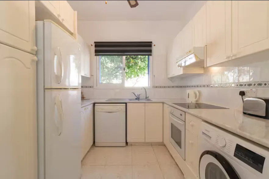 Kitchen with washing machine, dishwasher and garden window at Villa Nadezda
