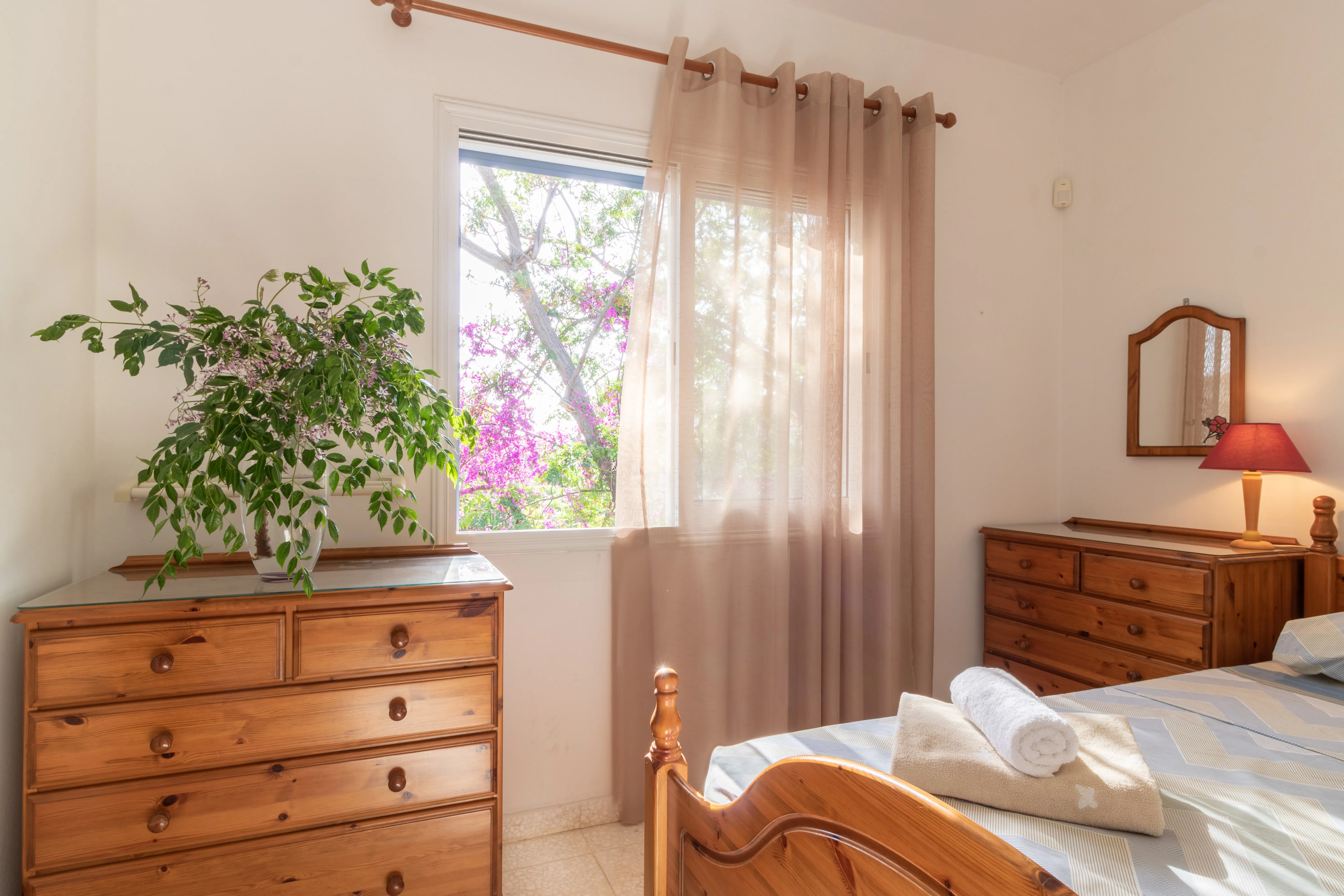 Bedroom with dresser, plants and view of bougainvillea at Villa Nadezda