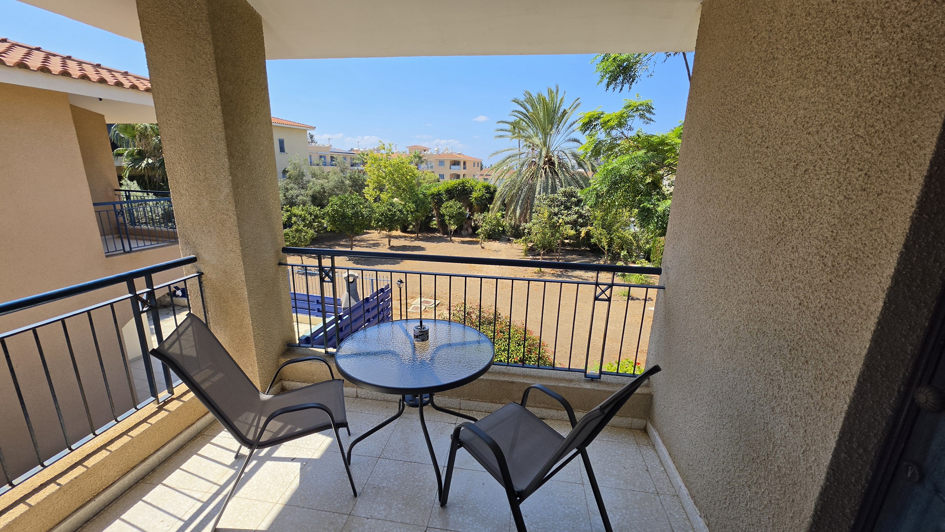Balcony at Villa Nadezda with table and chairs looking out over the gardens and palms
