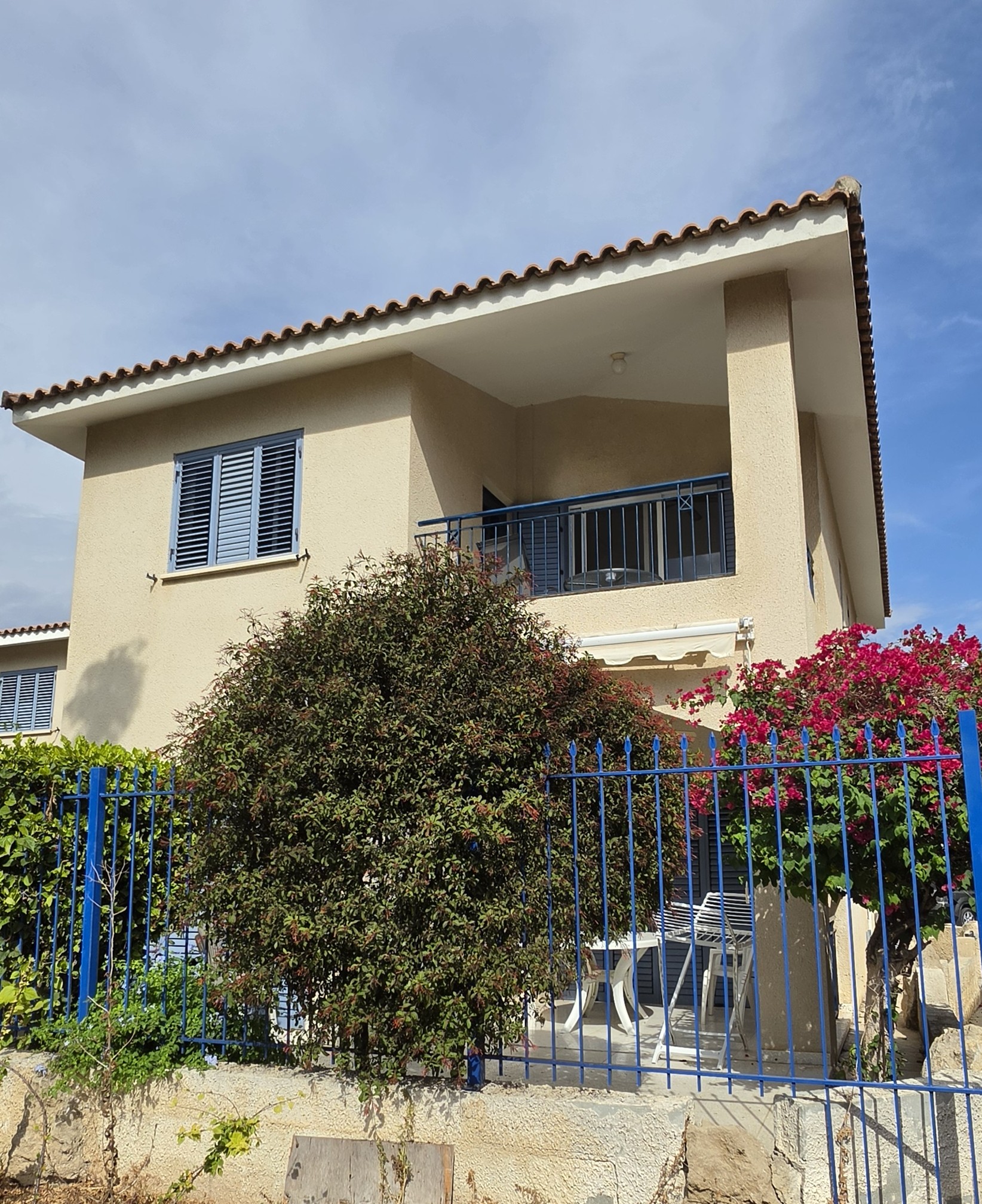 Villa Nadezda from the street, with bougainvillea over the blue gate and the balcony above, Kato Paphos