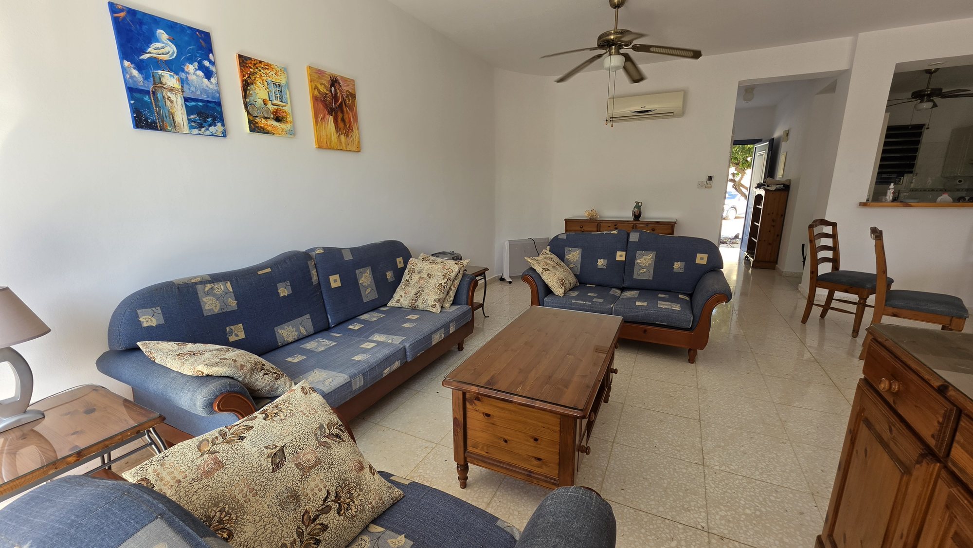 Living room of Villa Nadezda in Kato Paphos with sofas and hand-painted pictures on the wall