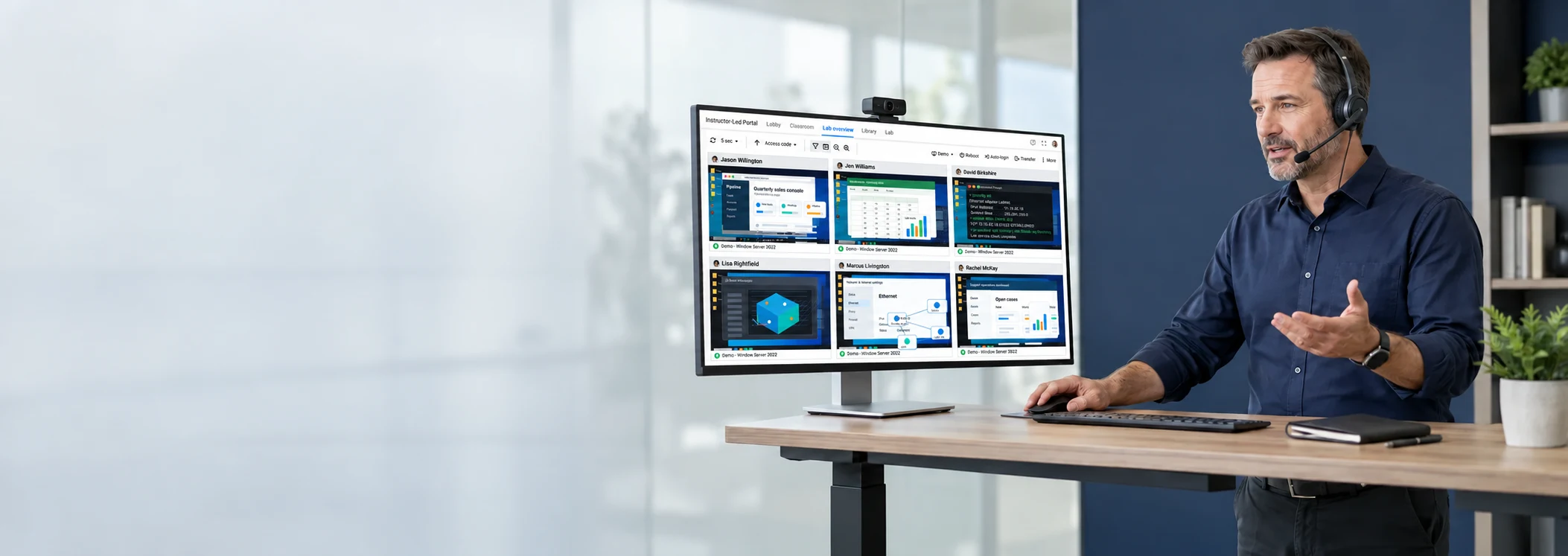 Instructor using ReadyTech Virtual Classroom with learner video on the large monitor and Lab Overview with active learner desktops on the laptop