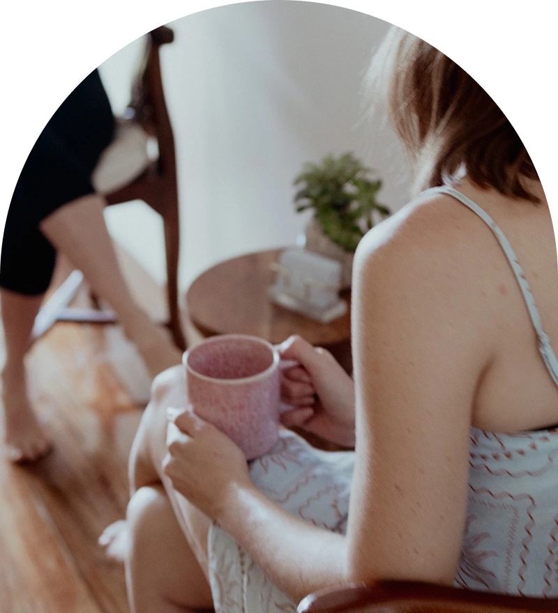Wellness client enjoying herbal tea during detox lifestyle coaching at Glow Colonics
