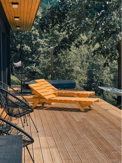 Terrasse en bois avec transat orange et vue sur la forêt d'un hébergement hôtel Ysotop à Grenoble.