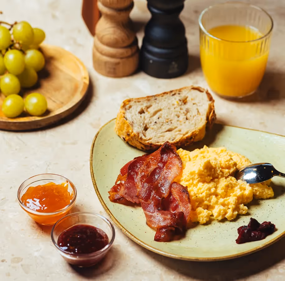 Assiette d'œufs brouillés et bacon du petit-déjeuner servi à l'hôtel 4 étoiles Ysotop à Grenoble.