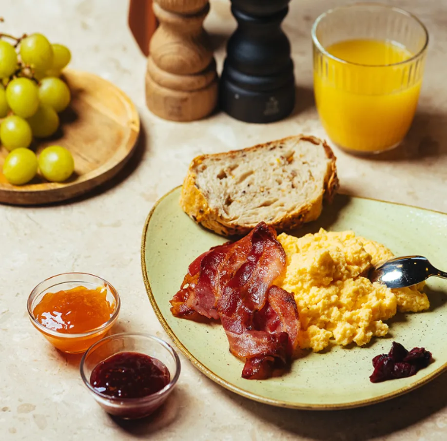 Assiette d'œufs brouillés et bacon du petit-déjeuner servi à l'hôtel 4 étoiles Ysotop à Grenoble.