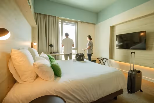 Bright double room with large bed and TV at the 4-star Ysotop hotel in Grenoble.