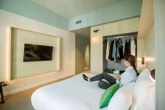 Comfortable room with integrated dressing room and wall-mounted TV at the Ysotop hotel in Grenoble Europole.