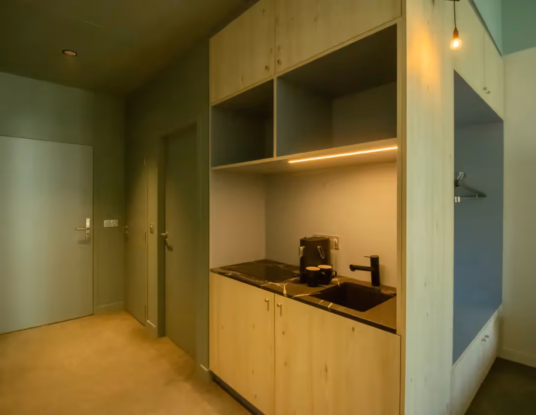 Kitchenette en bois clair avec machine à café et plaque de cuisson du studio appart'hôtel Ysotop Grenoble.