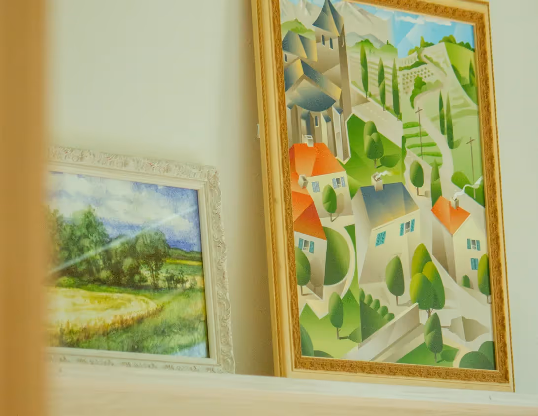 Peintures représentant un village de montagne et une prairie dans le studio de l'hôtel Ysotop Grenoble.