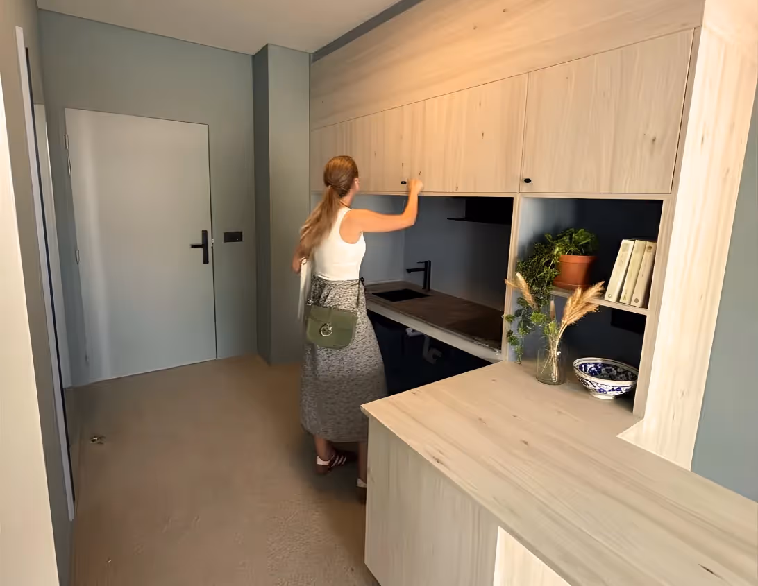Kitchenette équipée avec placards en bois clair et étagères décorées du grand studio appart'hôtel Ysotop Grenoble.